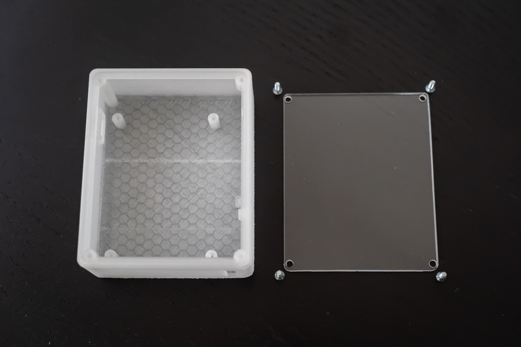 Left: 3D printed case in ABS. Right: Acrylic sheet cut to size.